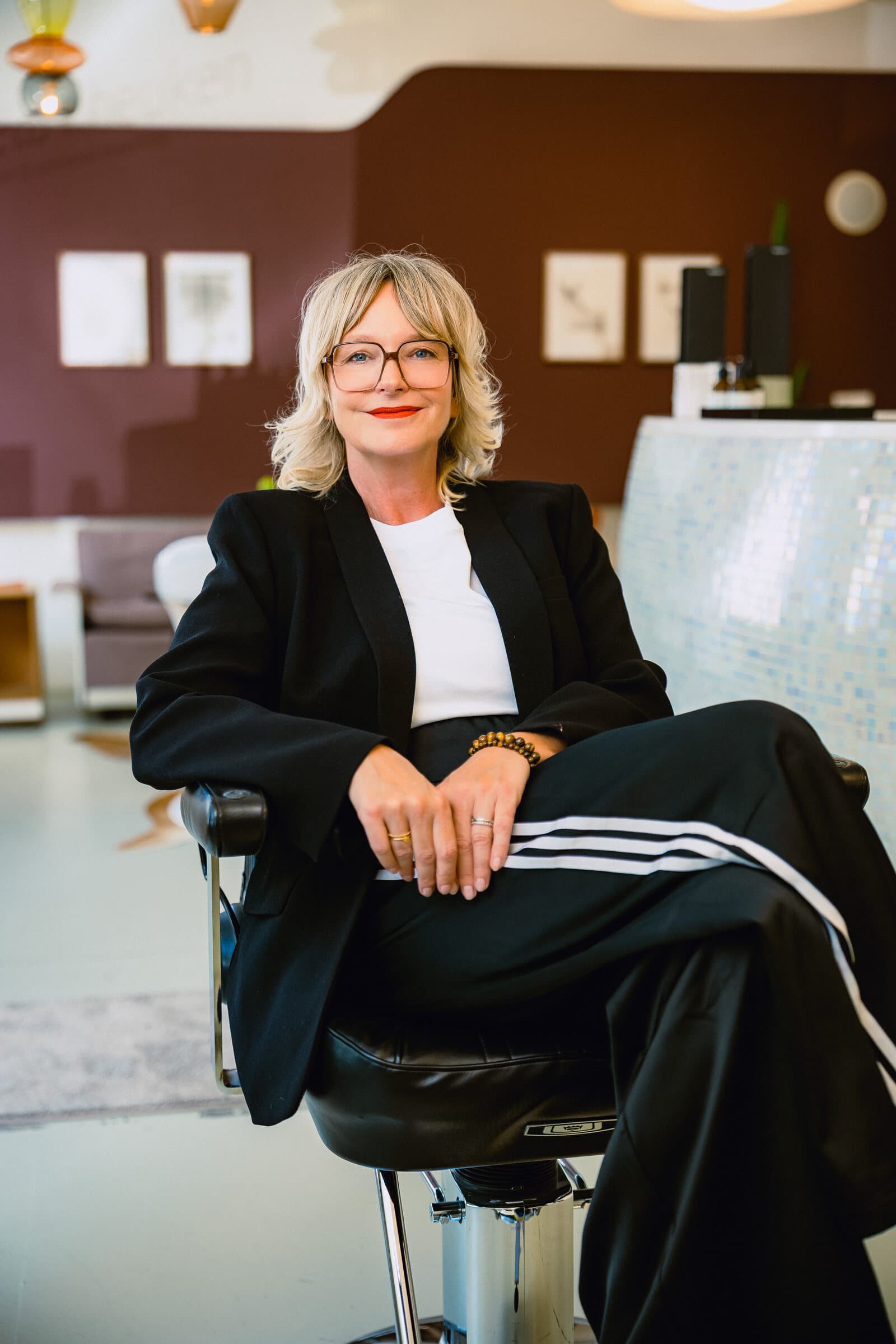 Manuela Heuken, sitzend vor der Weinwand ihres Studios